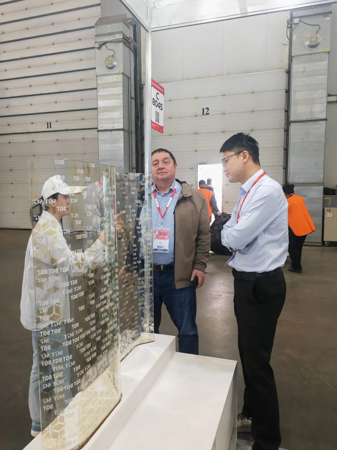 SGT sales manager introducing curved digital printed Low-E laminated glass sample at MosBuild exhibition